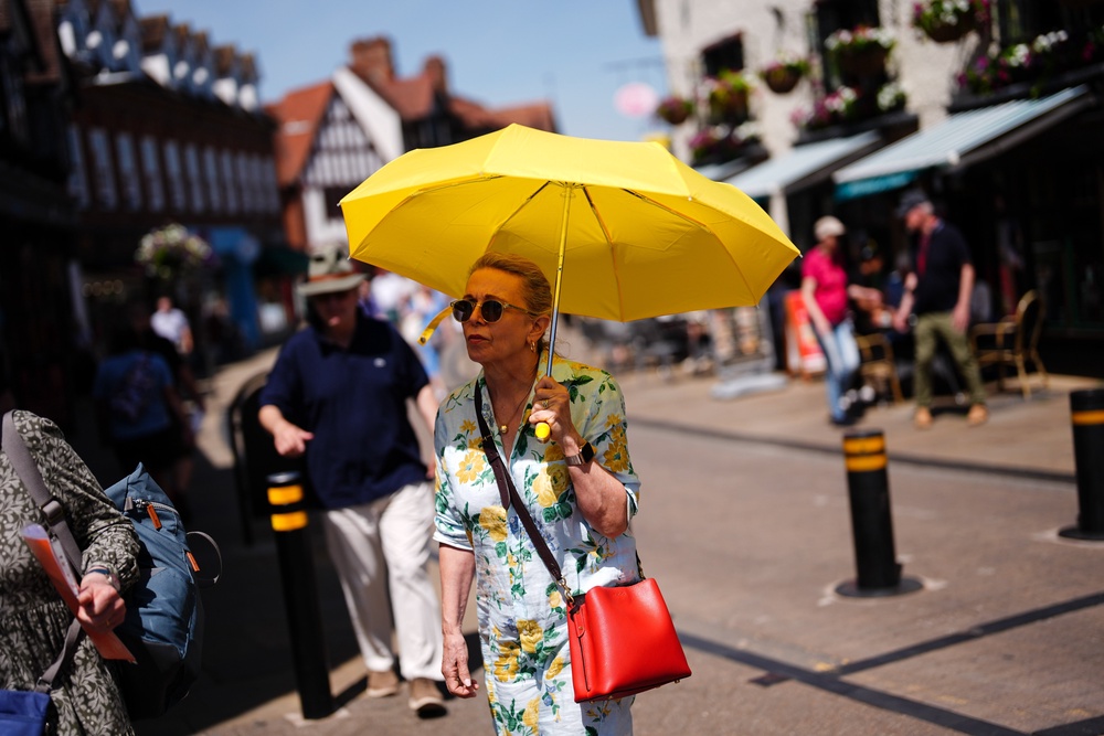 A woman holds an umbrella during hot weather in Stratford-upon-Avon, Warwickshire (Jacob King/PA) (PA Wire)