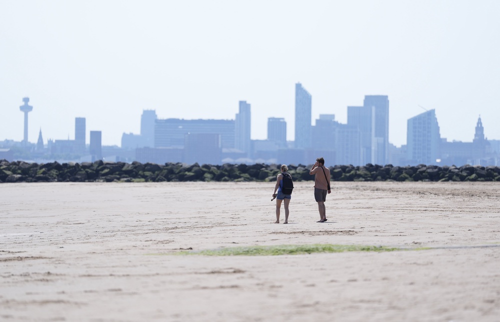 People walking on New Brighton Beach in The Wirral (Peter Byrne/PA) (PA Wire)