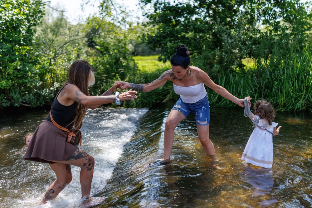 Sasha (centre) with her daughter Maureen (right) and friend Sammi (left) cool off in the River Darent on 19 June 2026 in Eynsford, United Kingdom (Getty)