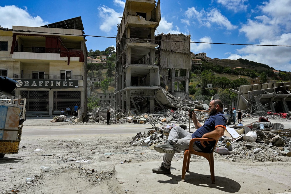 A man smokes a waterpipe as he sits by rubble in the town of Nabatieh al-Fawqa in southern Lebanon on June 23, 2026 (AFP/Getty)