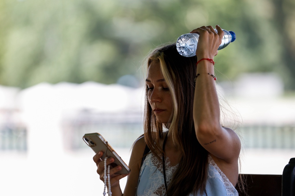 A woman uses a bottle of water to cool off at El Retiro Park in Madrid (Getty)