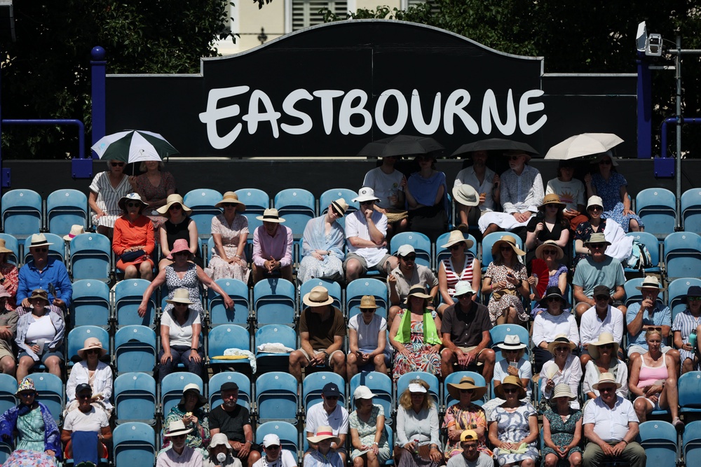 Spectators cover under umbrellas at Eastbourne (Reuters)
