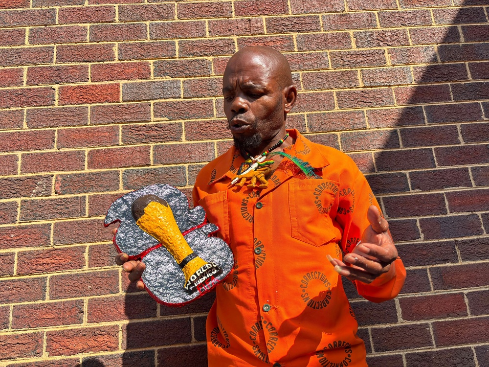 Freddy Mongkoai holding his artwork during an exhibition of inmates' artwork at the Leeuwkop Correctional Centre, in Johannesburg, South Africa (AP Photo/Kayleen Morgan)