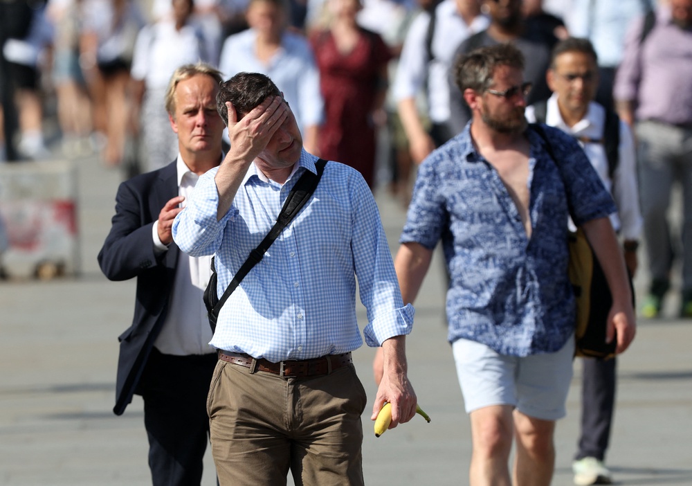 Commuters walk in the sun as they cross London Bridge (AFP/Getty)
