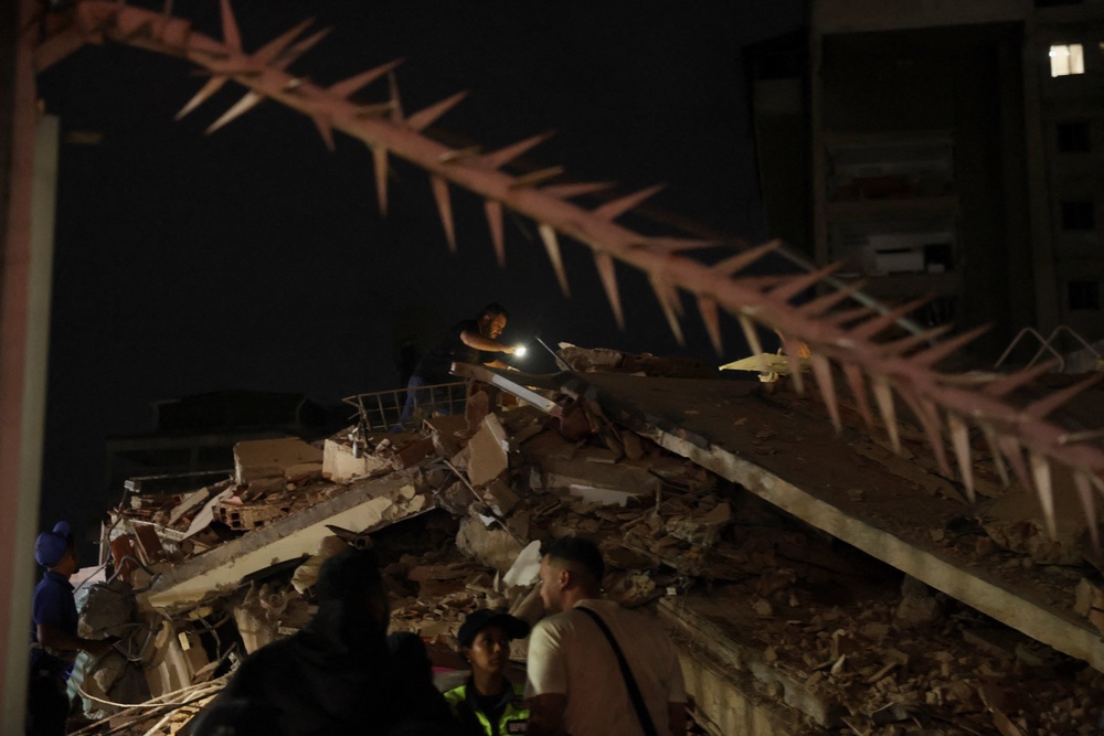 A person inspects the site of a collapsed building after an earthquake in Caracas, Venezuela, 24 June 2026 (Reuters)