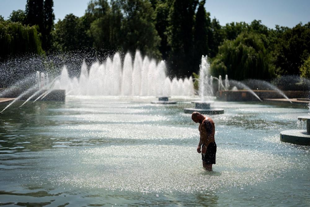 People enjoy the hot weather in Battersea Park, London. (PA)