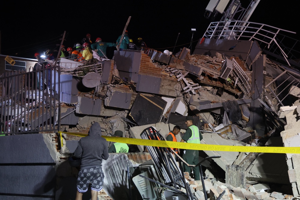 Firefighters and responders search for victims in the San Juan Tadeo demolished building at the El Paraíso urban development complex after two massive tremors (Getty)