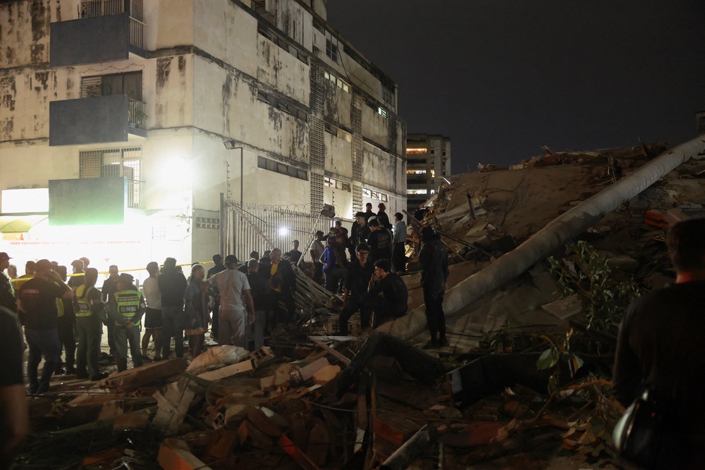 People gather at the site of a collapsed building after an earthquake in Caracas, Venezuela, 24 June 2026 (Reuters)