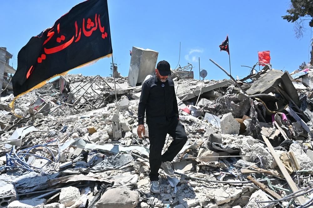 A resident walks on the rubble of homes and businesses, destroyed by the Israeli military, in the southern Lebanese village of Bir Al-Salasil on 24 June 2026 (AFP/Getty)