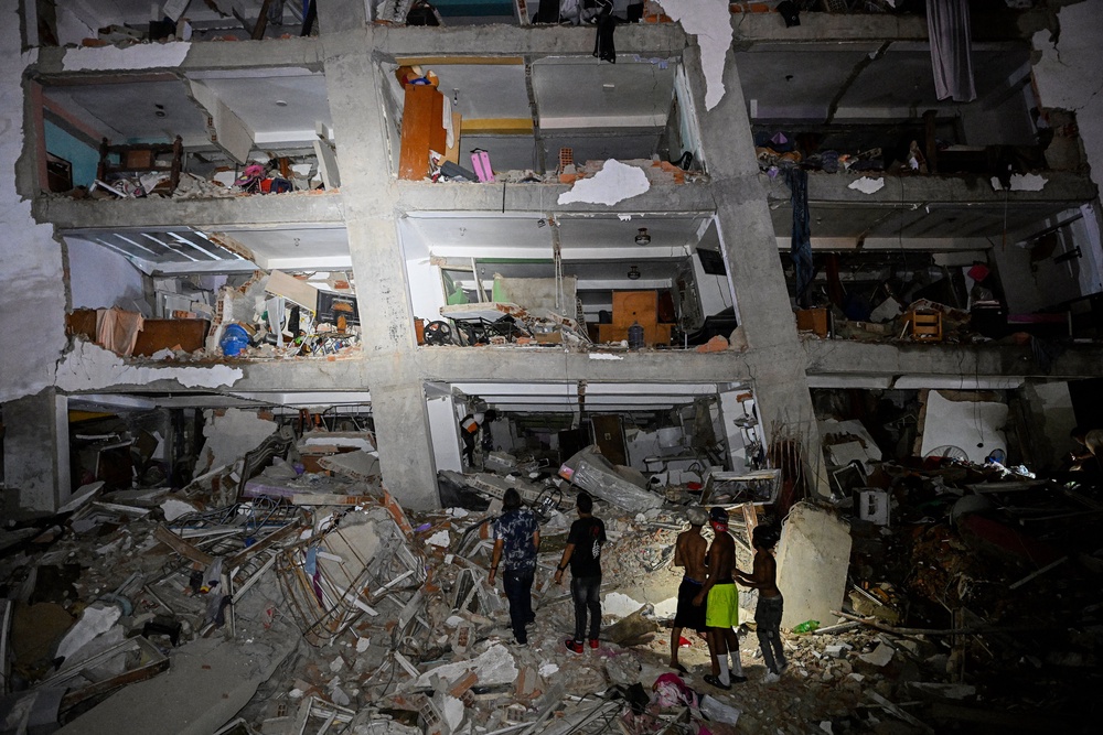 People stand in the rubble near a damaged building following an earthquake in Catia La Mar, La Guaira state, Venezuela (AFP/Getty)