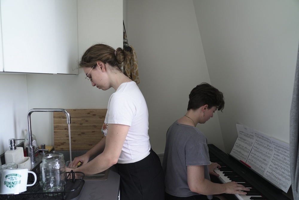 Amelie Kenney, right, plays piano in the attic apartment she shares with her partner Francesca Pilia, in Paris, Wednesday, June 24, 2026. (AP Photo/John Leicester) (AP)