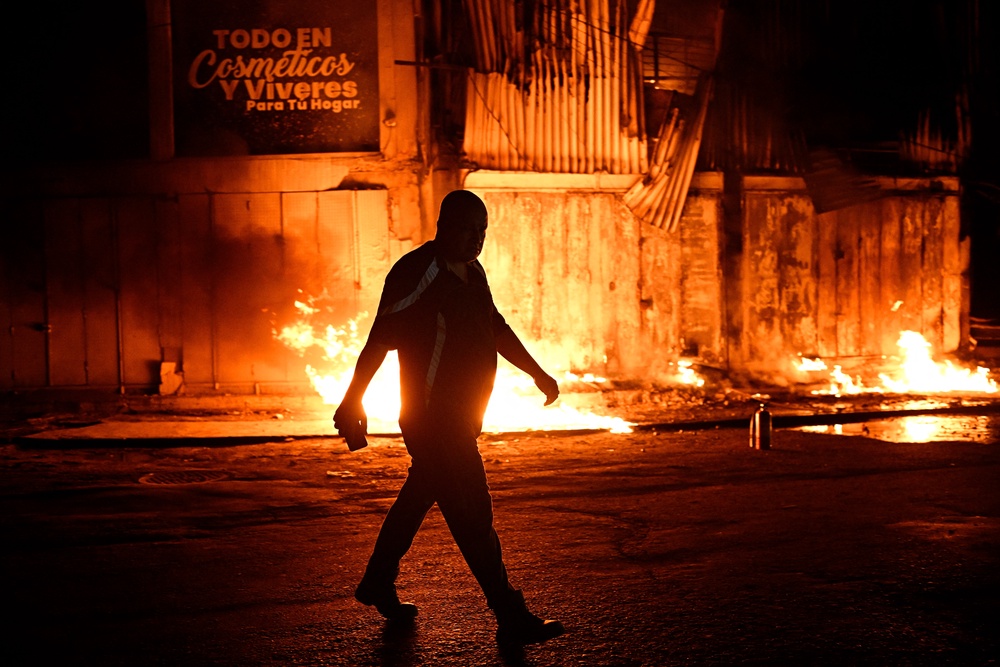 A man walks past a fire outside a building following an earthquake in Catia La Mar, La Guaira state, some 30kms north-west of Caracas (AFP/Getty)