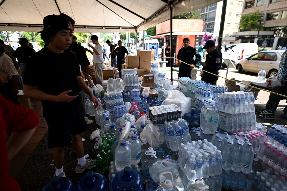 People sort and distribute bottled water and other relief supplies at a donation point following an earthquake (AFP/Getty)