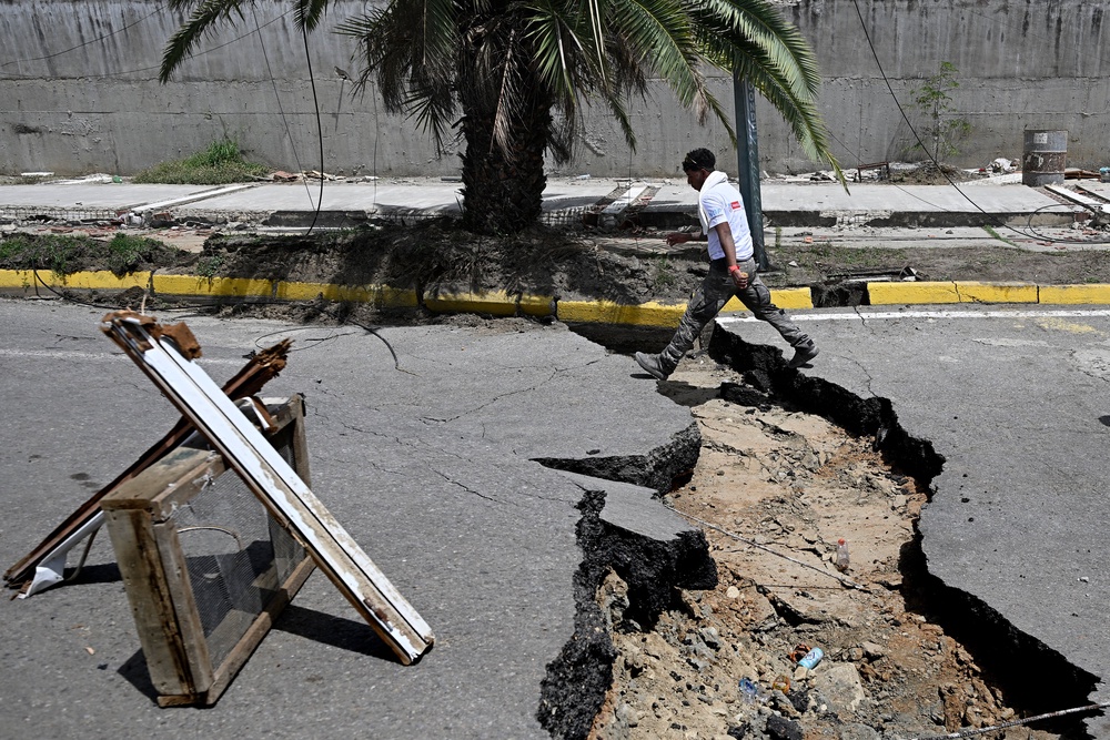 A man walks in a cracked street following a twin earthquake, in Los Corales (AFP/Getty)
