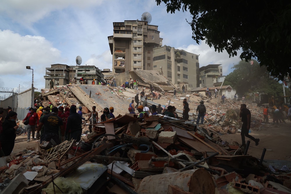 People and rescuers work on the debris from the Moises building on Avenida Anauco (Getty Images)