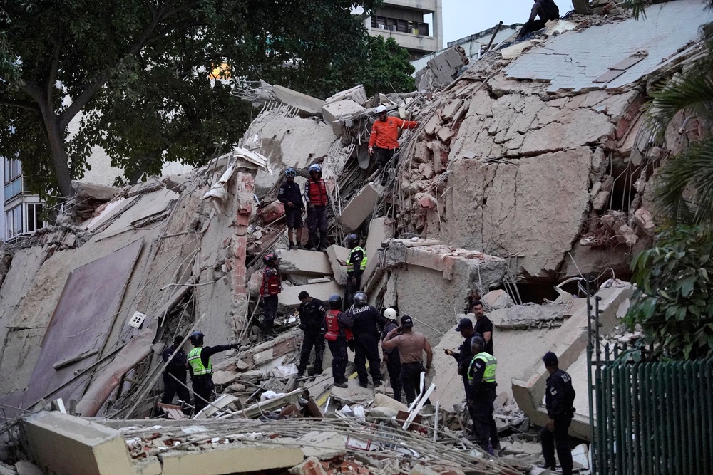 Rescuers search for victims in a collapsed building (AFP via Getty Images)
