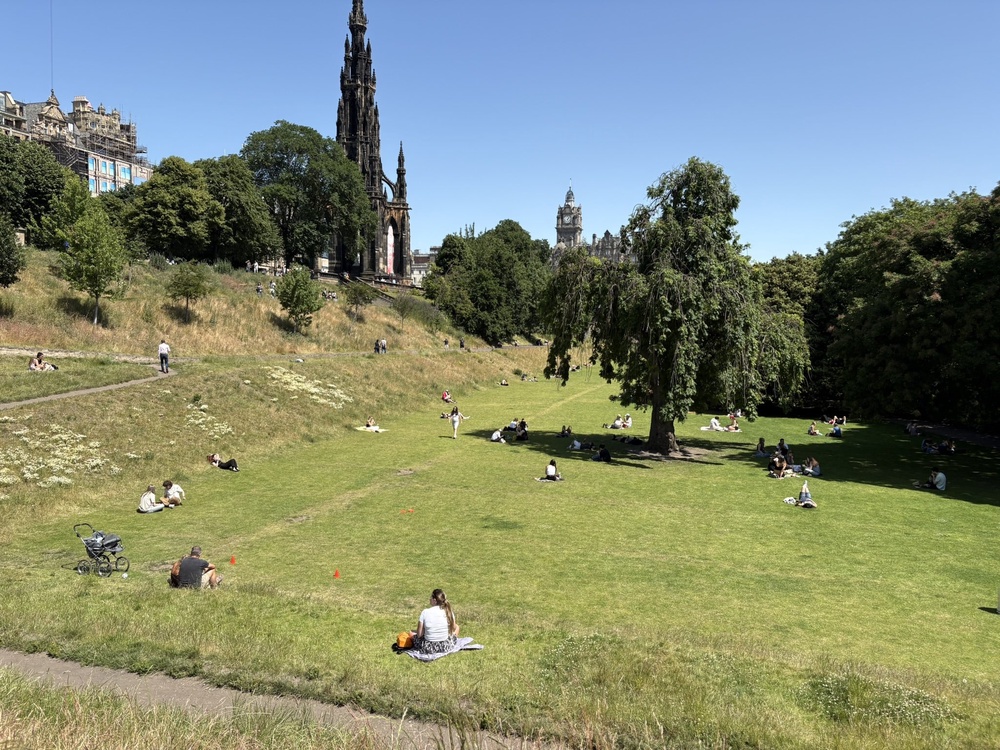 People enjoy the hot weather in Edinburgh (PA) (PA Wire)