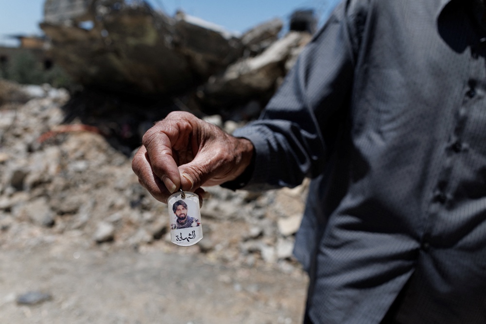The man shows a photo of his son, who, according to him, was a Hezbollah fighter and was killed by an Israeli strike (Reuters)