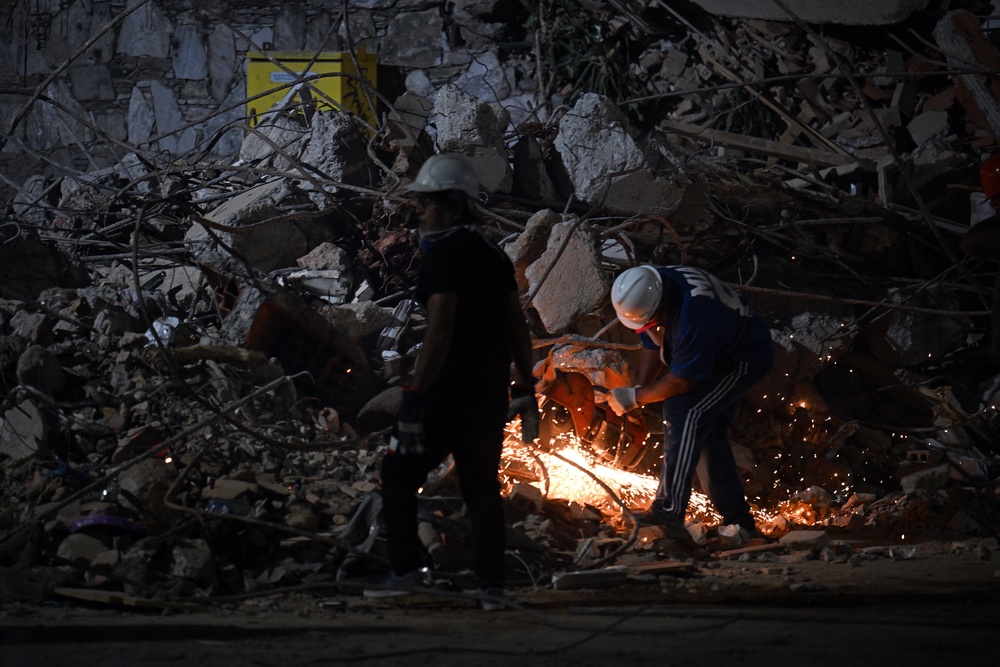A rescuer cuts the steel bars of a collapsed building with an angle grinder in Caracas on June 25, 2026, following deadly earthquakes. Using heavy equipment or their bare hands, rescuers and volunteers searched for survivors of the twin earthquake in Venezuela, which has officially left 920 dead and, according to estimates, thousands missing (AFP/Getty)