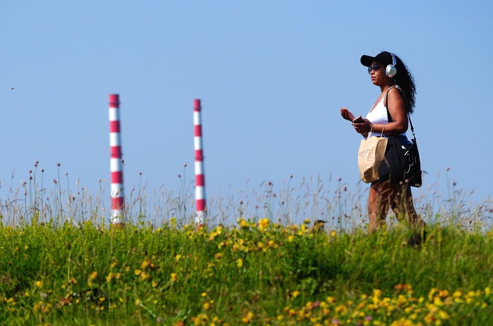 A person walks in the sunshine on Bull Wall in Dublin as the hot weather continues (Brian Lawless/PA) (PA Wire)