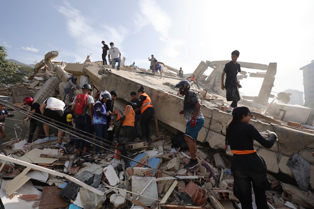 People and rescuers search for victims amid debris in La Guaira (Getty Images)