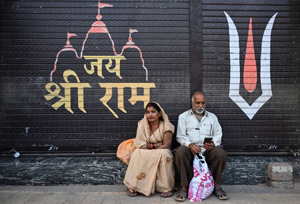 People rest outside a closed shop near Ram Mandir (AFP via Getty)