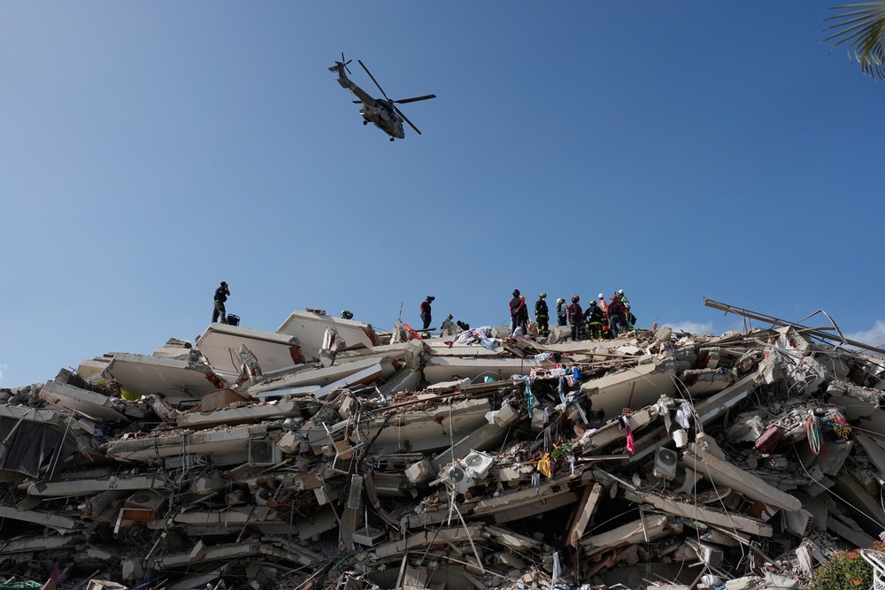 Rescue workers search through the rubble three days after earthquakes struck Catia La Mar (AP)
