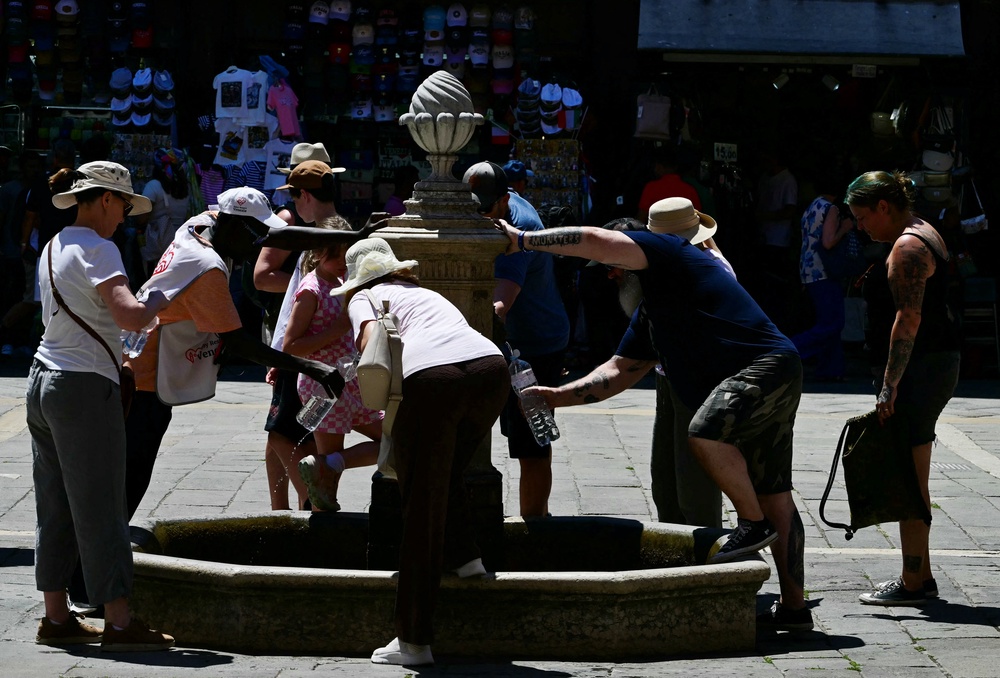 People fill bottles from a public water fountain during a heatwave in Venice (AFP/Getty)