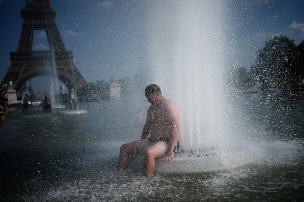 A person cools off at Trocadero fountain near the Eiffel Tower during a heat wave in Paris, on June 24, 2026. (AP Photo/Christophe Ena, File) (Copyright 2026 The Associated Press. All rights reserved.)