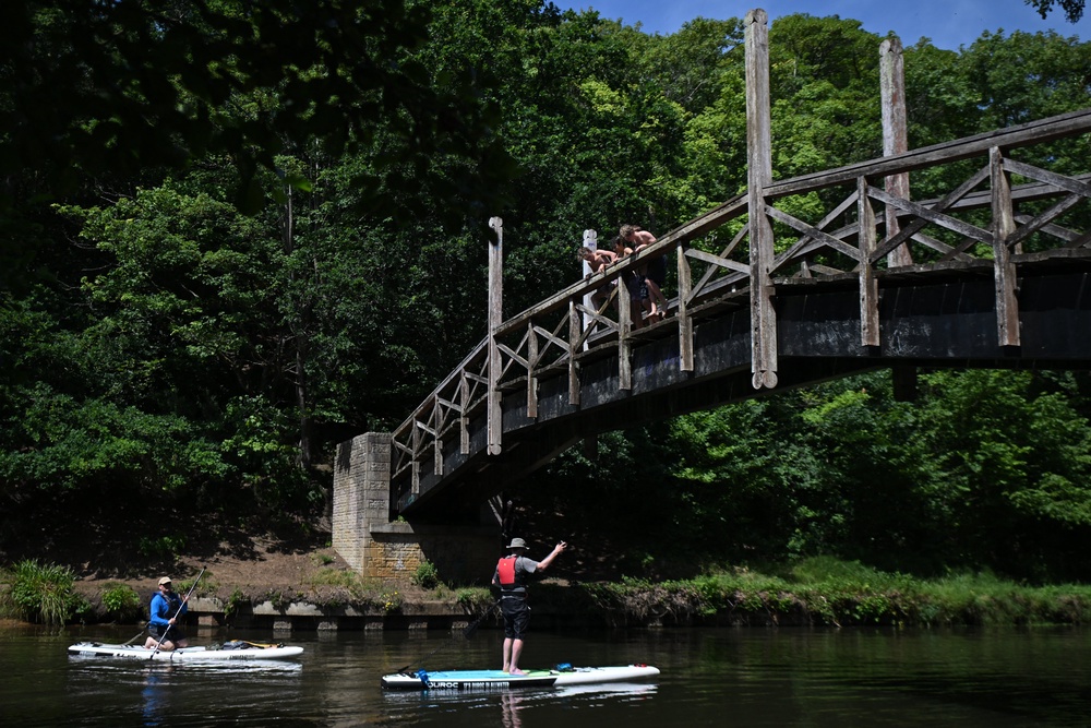 Paddleboarders pass under a bridge on the River Wey, near Guildford, amid the soaring temperatures (AFP/Getty)