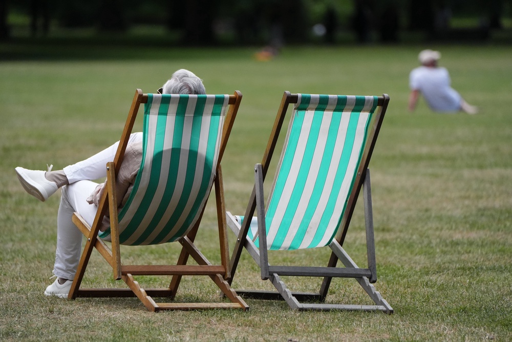 People enjoy the hot weather in Green Park, London, on Sunday (Jonathan Brady/PA) (PA Wire)