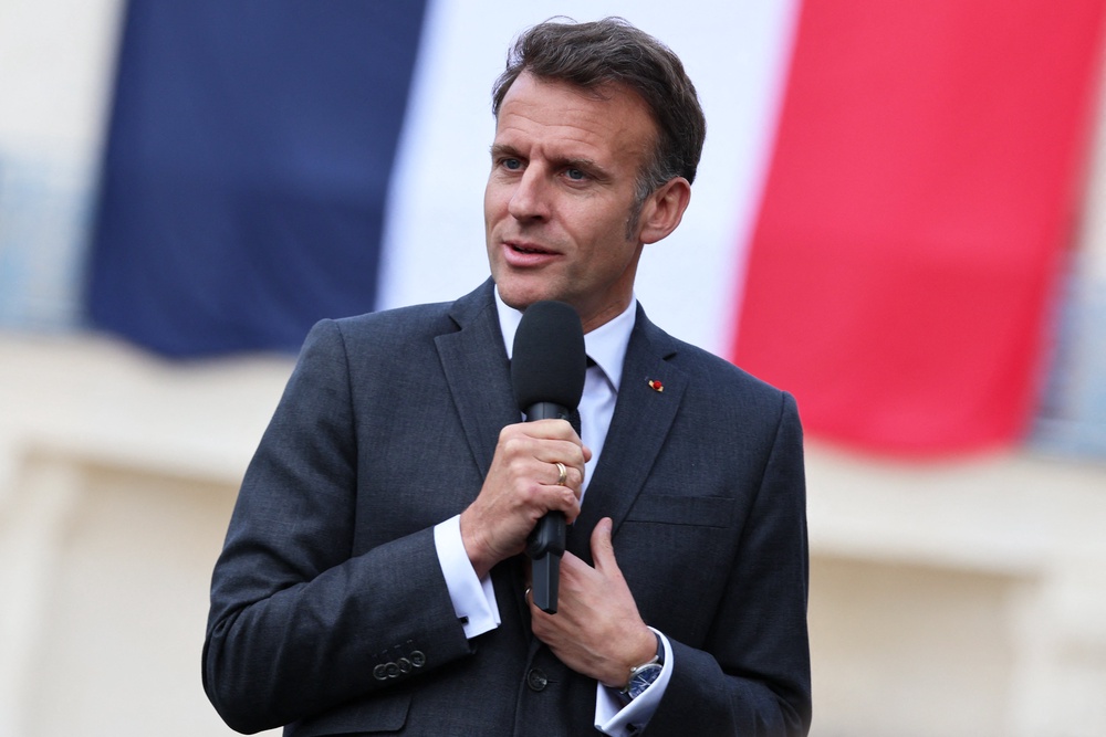 France's President Emmanuel Macron delivers a speech with a French flag in the background during his visit to the International City of French Language (Cite Internationale de la Langue Francaise) to promote 'disconnecting' and 'reading' as alternatives to screens as part of his fight to ban social networks for the youngest (POOL/AFP via Getty Images)