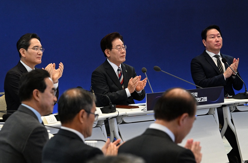South Korean President Lee Jae Myung (C), Samsung Electronics Chairman Lee Jae-yong (L) and SK Group Chairman Chey Tae-won (R) attend the briefing announcement of public-private collaboration projects at the presidential Blue House in Seoul (POOL/AFP via Getty Images)