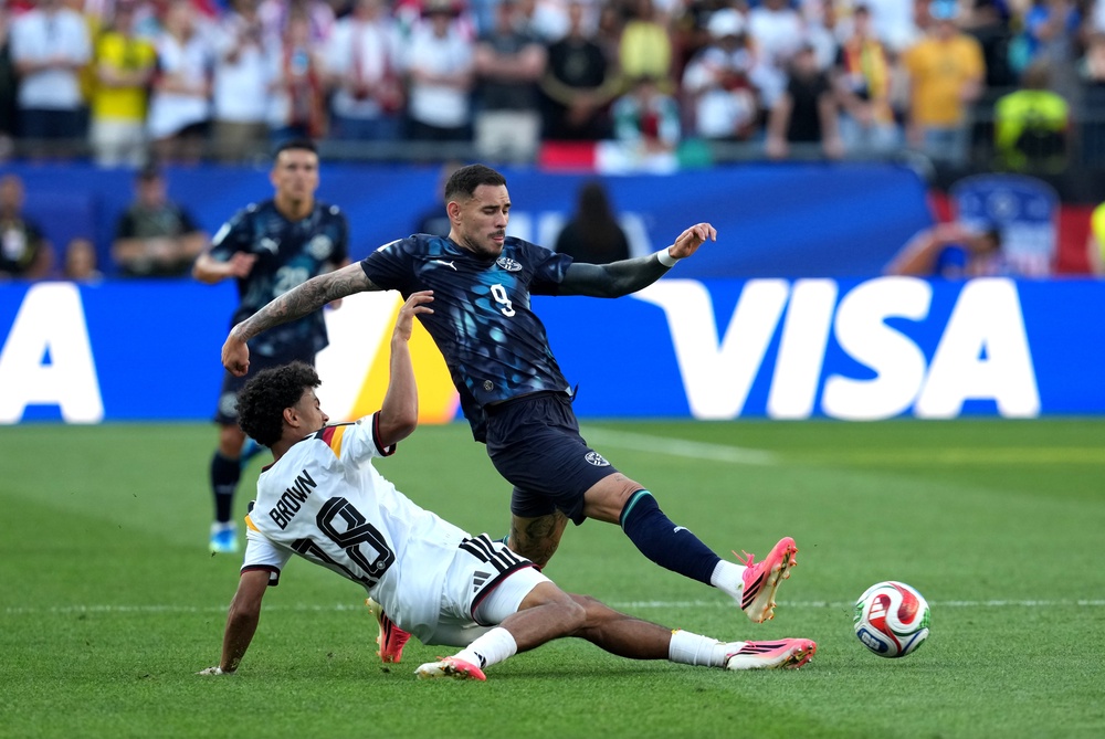 Germany's Nathaniel Brown (left) and Paraguay's Antonio Sanabria battle for the ball (PA)