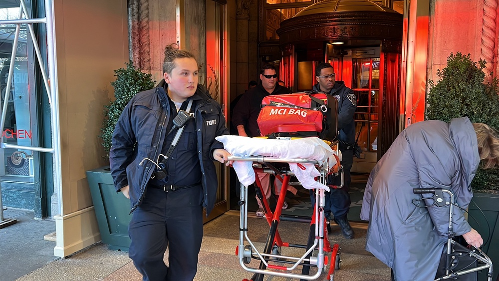 New York Fire Department emergency personnel walk an empty gurney from the Sherry-Netherland Hotel where fire broke out in Chinese tycoon Guo Wengui's penthouse apartment in the Upper East Side of New York city on 15 March 2023 (AFP/Getty)