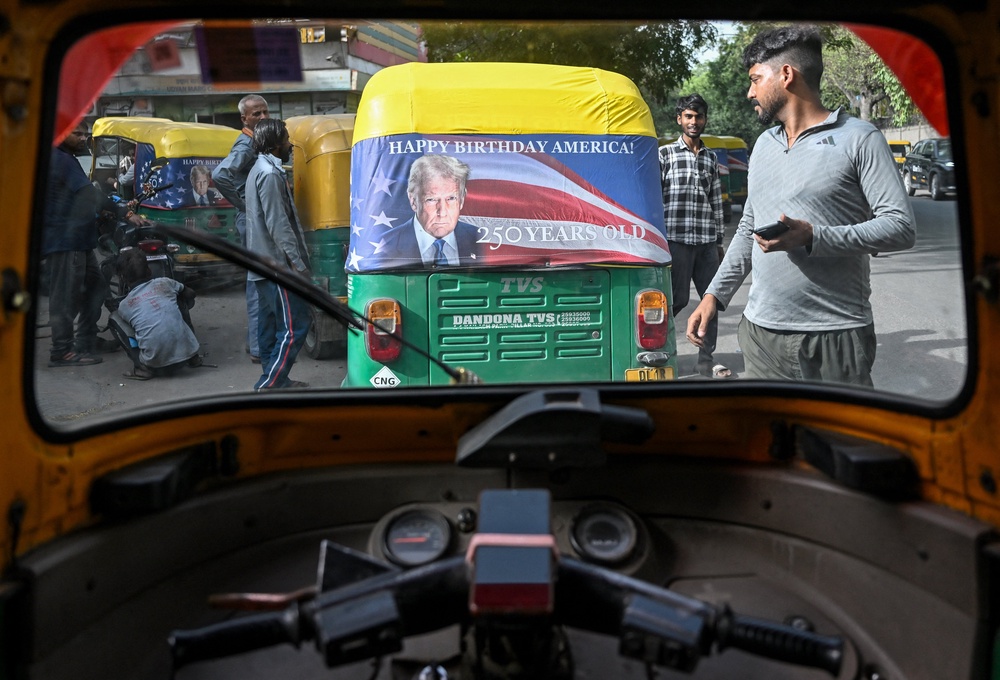 Workers fix a poster featuring US President Donald Trump on an autorickshaw in New Delhi on May 21, 2026 marking the 250th anniversary of American independence (AFP/Getty)