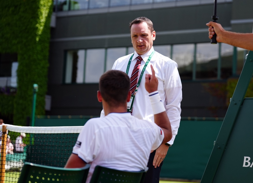 Damir Dzumhur speaking with match referee Jake Garner (PA)