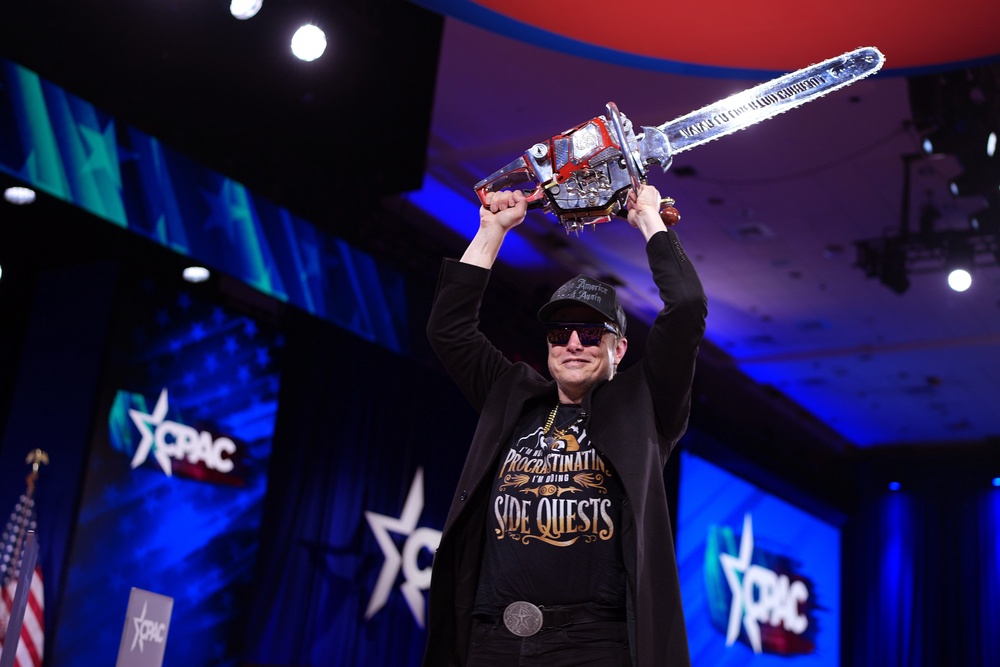 Elon Musk leaves the stage holding a chainsaw after speaking at the Conservative Political Action Conference (CPAC) at the Gaylord National Resort Hotel And Convention Center on February 20, 2025 in Oxon Hill, Maryland (Getty)