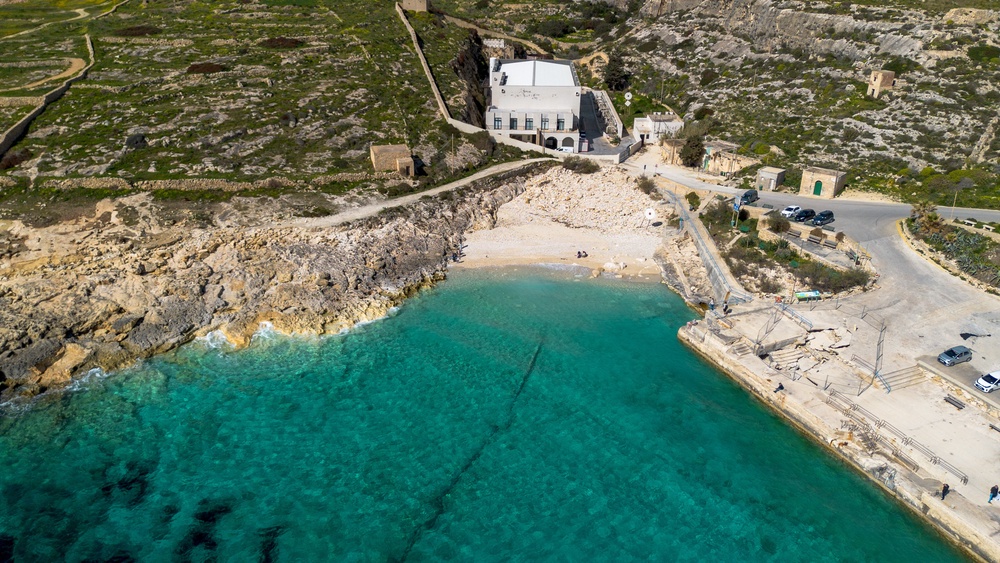 Aerial view of the Hondoq ir Rummien ir-rummein desalination plant, rocky shoreline, small beach and offshore brine outfall pipe visible in the turquoise Mediterranean water in Qala, Gozo, Malta (Hans Lucas/AFP via Getty Images)