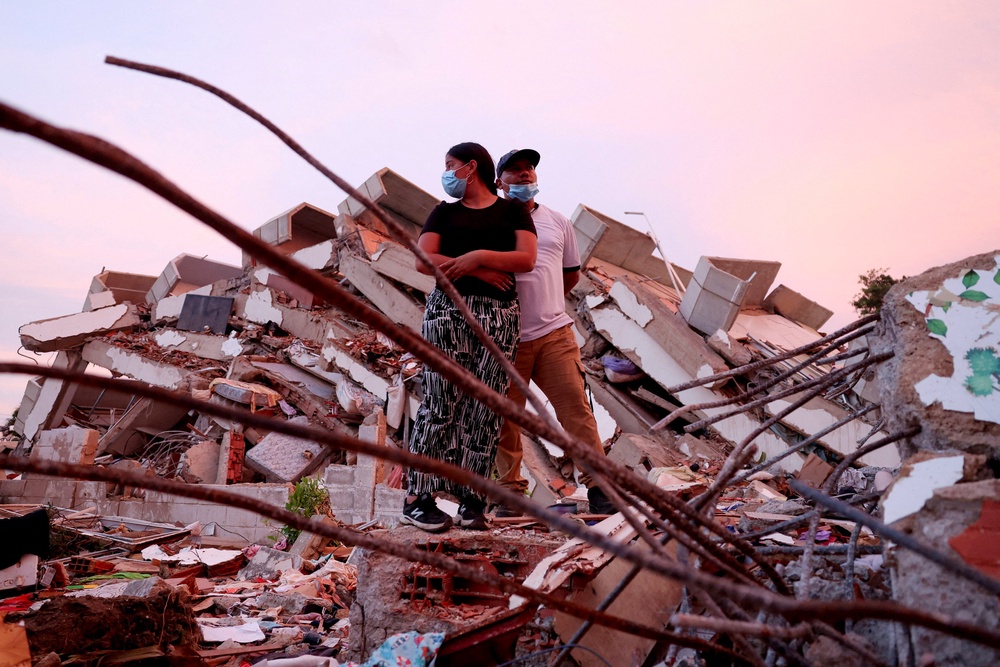 Yohancy Gil, 24, and her husband Sergio Guanipa, 30, wait for news from rescue teams looking for their children under the rubble of a collapsed building in La Guaira (Reuters)