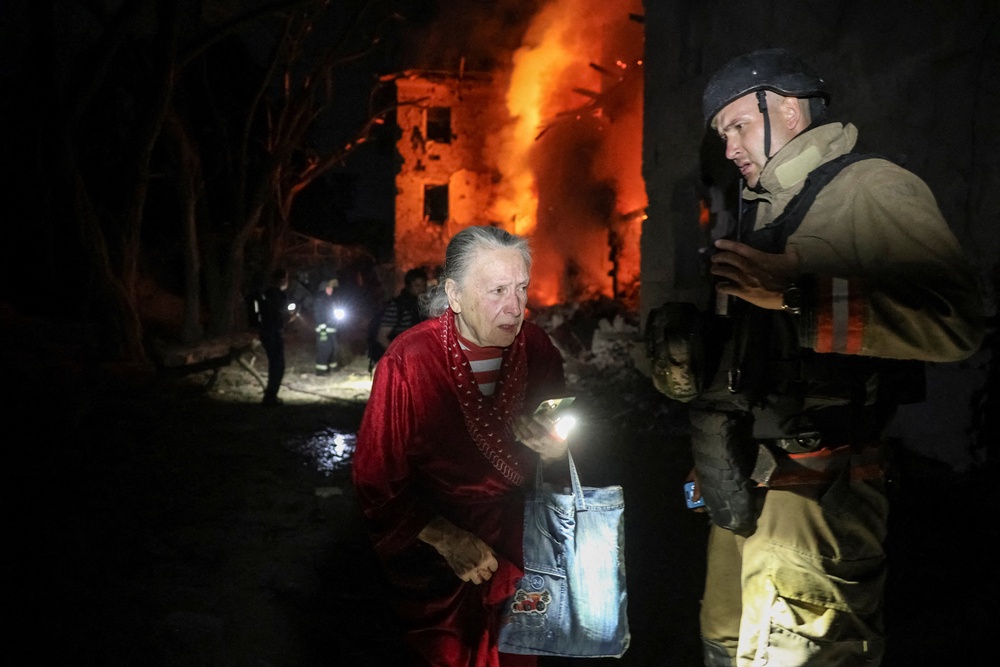 A rescuer evacuates a resident Valentina Kolokolova, 76 (Reuters)