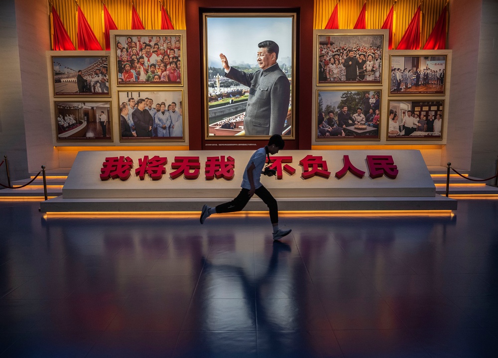 A boy runs past a portrait of Xi Jinping as he visits the Museum of the Communist Party on the 105th anniversary of its founding (Getty)