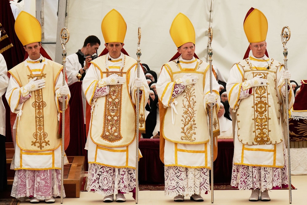 Newly consecrated Bishops, from left, Marc Hanappier, Michel Poinsinet de Sivry, Michael Goldade and Pascal Schreiber wearing their miters and holding their pastoral staffs, stand at the end of their consecration ceremony in a tent set up outside the Society of St. Pius X seminary in Econe, Switzerland, Wednesday, July 1, 2026 (AP Photo/Baz Ratner)