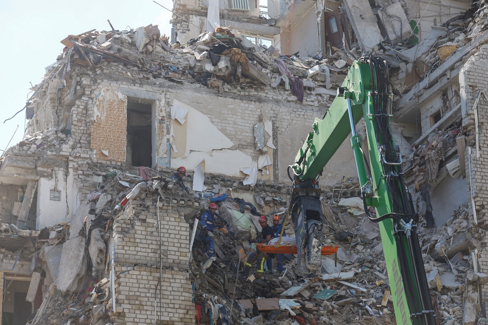 Rescuers use a crane to carry the body of a killed person found under debris of an apartment building damaged during overnight Russian missile and drone strikes (Reuters)