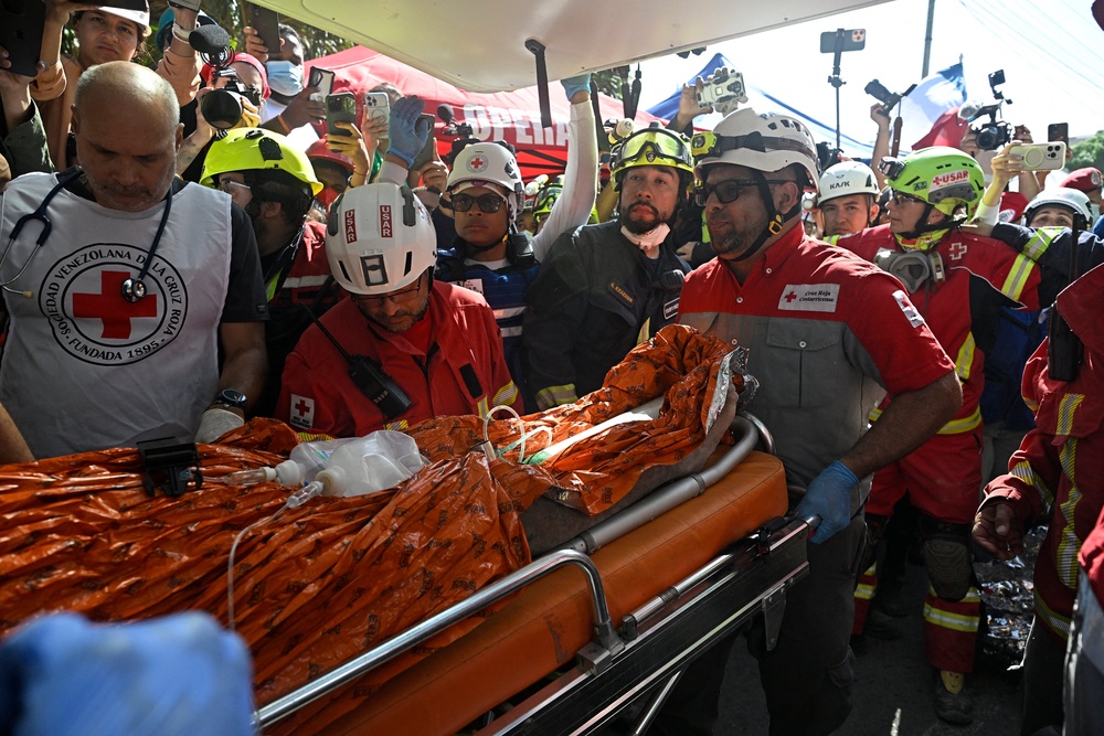 An international rescue team loads Hernan Gil, a survivor of Venezuela's twin earthquakes, into an ambulance in Catia La Mar, La Guaira State, Venezuela on July 2, 2026, eight days after the quake (AFP/Getty)