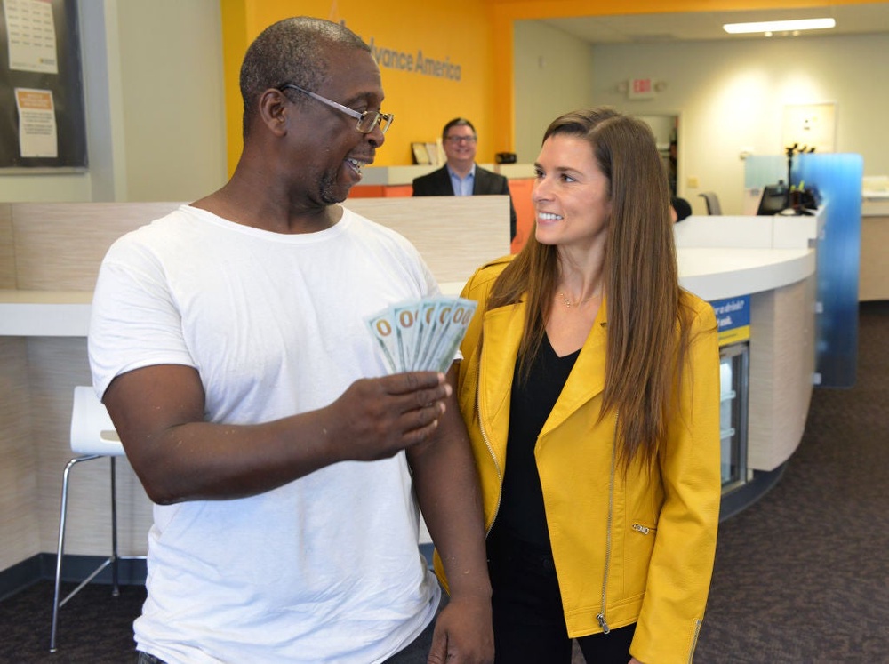 Professional Race Car Driver and Advance America Brand Ambassador Danica Patrick surprises customer Ernest Colston by paying his bill in celebration of Advance America's 20th Anniversary Sweepstakes  on August 15, 2017, in Spartanburg, South Carolina. Experts typically recommend against borrowing money from payday lenders, as fees are high for the small amount of money that's borrowed (Brian Gomsak/Getty Images for Advance America)