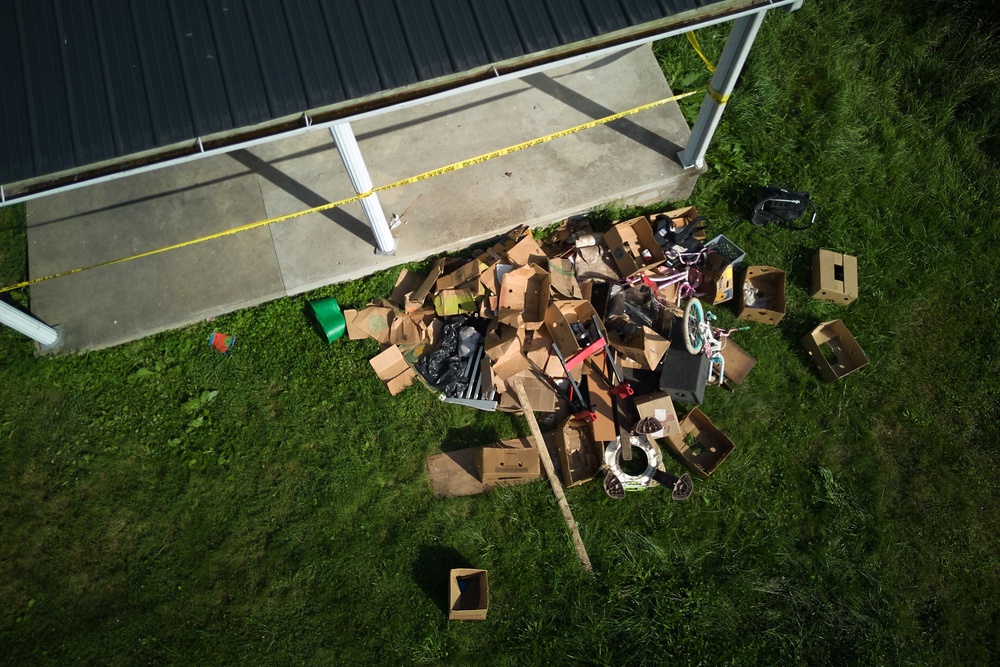Debris is strewn on the front lawn of the home (AP)