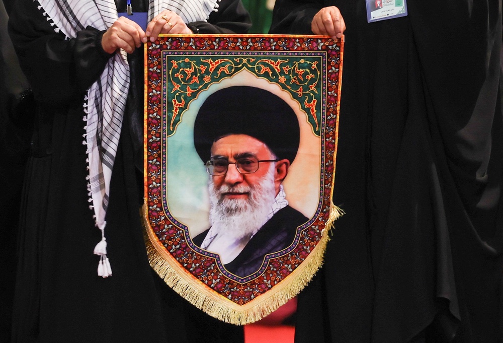Women hold an image of Iran's late Supreme Leader Ayatollah Ali Khamenei (Reuters)