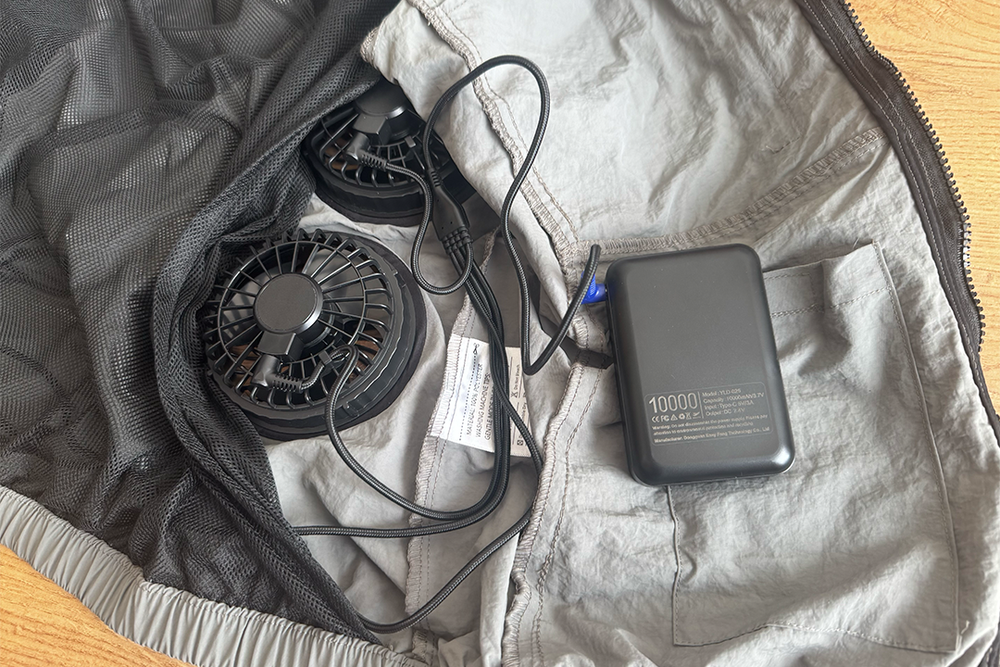 The fans plug into a power bank, that can be tucked into a little pocket (Alex Lee/The Independent)