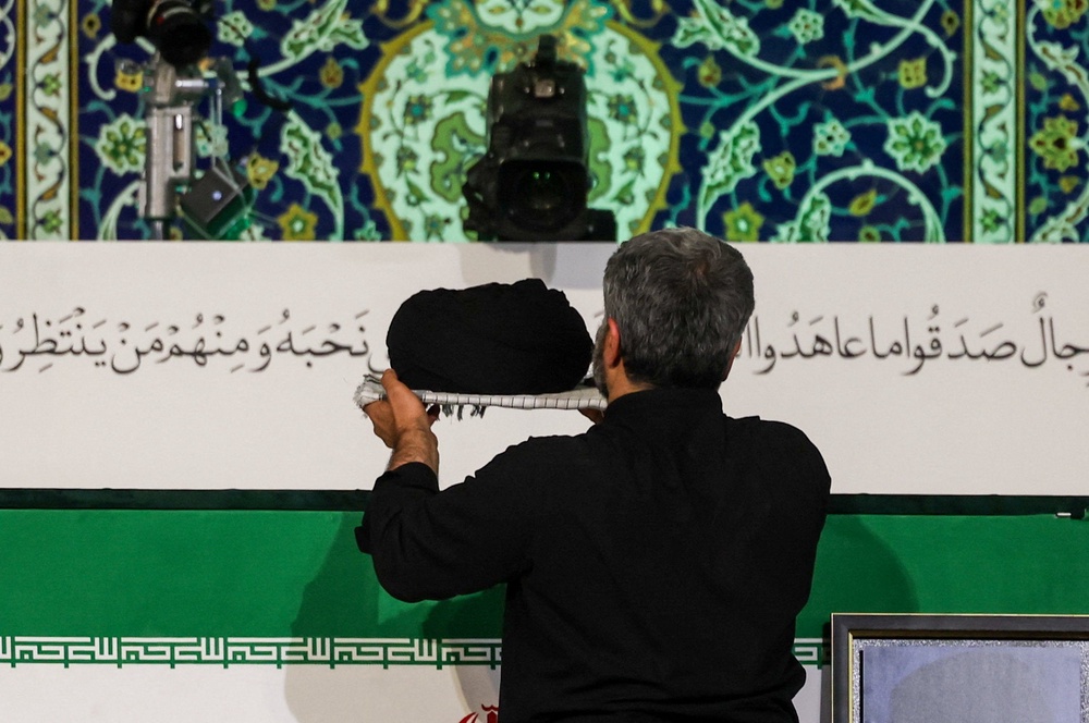 A man places a turban over the coffin of Iran's late Supreme Leader Ayatollah Ali Khamenei on Friday (Reuters)